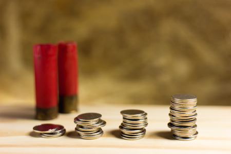 Still life.Staircase of money, Thai coins of one bath on wood and Shotgun shell background.Concept of financial planning and savings.の写真素材