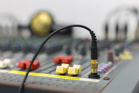 Photograph of a DJ's Headphone jack in the socket, taken close up with a shallow depth of field....