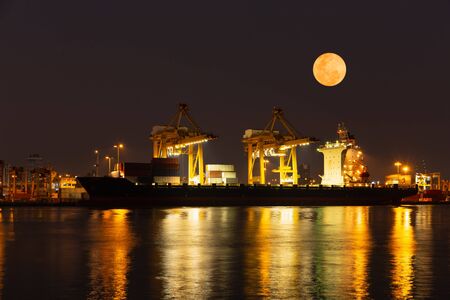 Super moon and cargo Containers loading Shipping by crane at night time.の写真素材