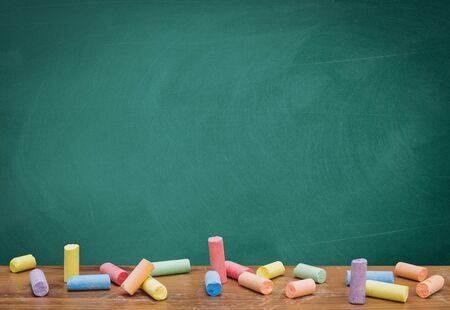 Group of colorful chalks and a blackboard or chalkboard background, concept for education, banner, startup, teaching , etc.の写真素材