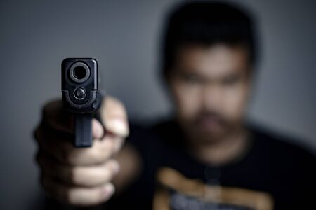 men pointing a gun at the target on gray background,  selective focus on front gun,