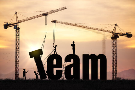 Silhouettes of people and cranes constructing the word "Team" during sunrise, representing collaboration, leadership, teamwork, and shared goals. Ideal for business, HR, management, or project development visuals.の写真素材