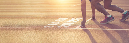 Athlete in starting position on running track with START 2026 text, symbolizing new beginnings,...