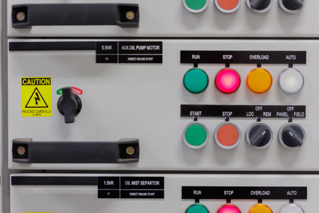 Description: A clear view of an industrial control panel featuring push buttons, indicator lights (RUN, STOP, OVERLOAD), and a selector switch. The image highlights operational controls and safety features of industrial machinery, like a 5.5kW pump motor.の写真素材