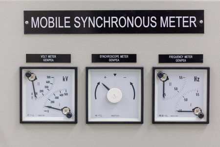 A close-up view of a mobile synchronous meter control panel featuring analog gauges for measuring...