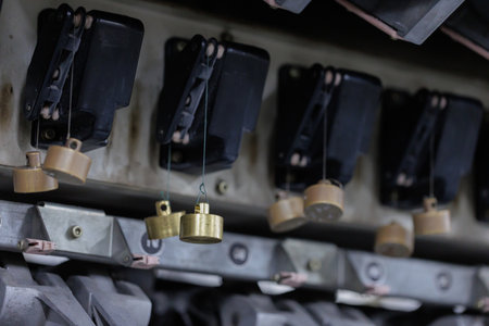 An engineer is using a steel weight to calibrate a fiber tension meter.