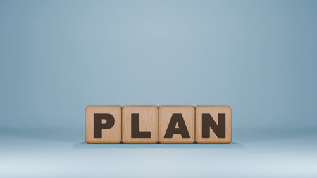 Four wooden dice spelling out 'PLAN' on a light blue background, symbolizing strategy and planning...