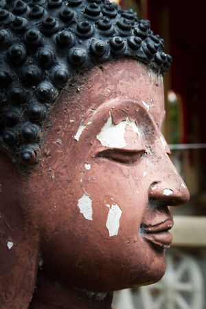 Half of a buddha face at the temple on nature backgroundの写真素材