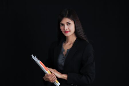 Portrait of young asian businesswoman with document  on black background.の写真素材
