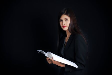 Portrait of young asian businesswoman with document  on black background.の写真素材