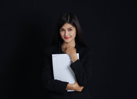 Portrait of young asian businesswoman with document  on black background.の写真素材