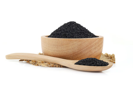 Black sesame in a wooden bowl with spoon on sack isolated on white backgroundの写真素材