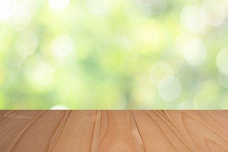 Wood table top on blur abstract green from garden in the morning background, green bokeh, can be used for display or montage your productsの写真素材
