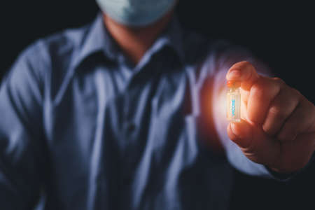 Doctor on black background, Concept fight against virus, doctor or scientist in laboratory holding a liquid vaccines, Conceptdiseases,medical care,science.の写真素材