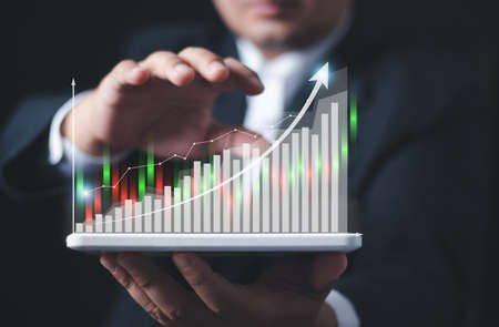 Businessman or trader is showing a growing virtual hologram stock. , planning and strategy, Stock market, Business growth, progress or success concept. , invest in trading.の写真素材