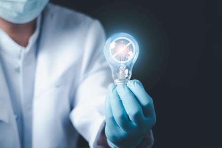 Doctor or scientist in laboratory holding a light bulb, Concept fight against virus , Conceptdiseases,medical care,science.の写真素材