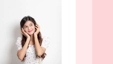 Portrait of happy young asian woman put on headphones listen to music, Beautiful smiling thai girl on white backgroundの写真素材