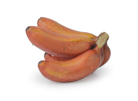 red bananas on a white background. The bananas are arranged in a cluster and are a bright red color. The bananas are ripe and ready to eat.の写真素材