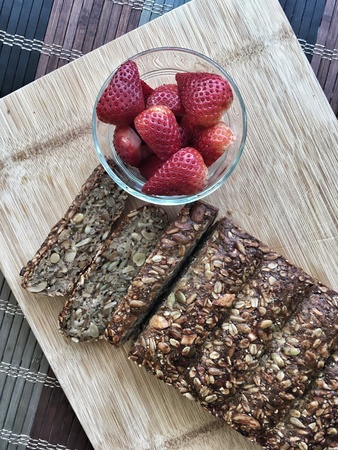 Healthy vegan nut loaf with strawberries on cutting boardの素材