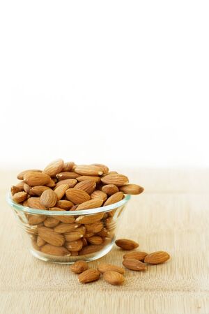 almonds in a glass bowl on a cutting boardの写真素材