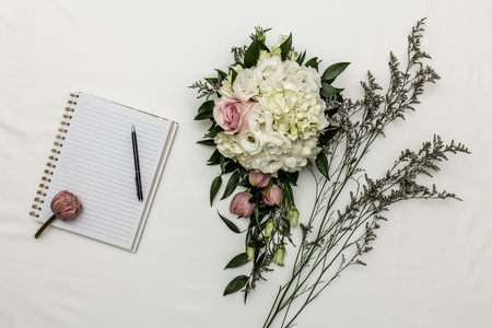 flower arrangement with notebook and penの写真素材