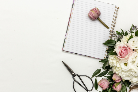 Flower arrangement flat lay with notebook and scissorsの写真素材