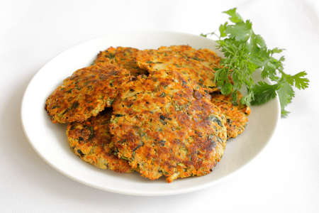 Close up of zucchini patties on a white plate.の写真素材