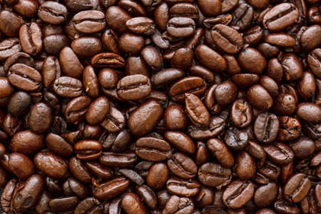 Roasted coffee beans spread flat filling entire frame.の写真素材