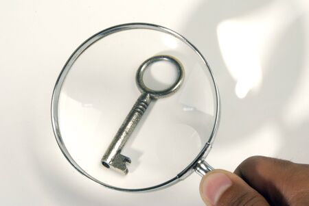 An old key under a magnifying glass の写真素材