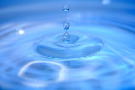 A drop of water above water surface - water splash