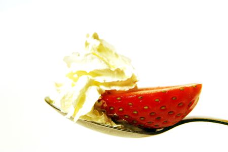 strawberries and cream on a spoon ready to eatの写真素材