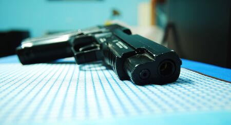 A new generation pistol on a blue table ready to be usedの写真素材
