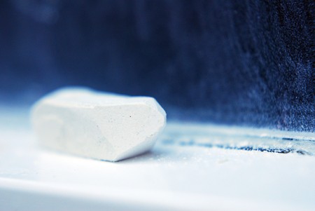 a white piece of chalk macro near a black tableの写真素材