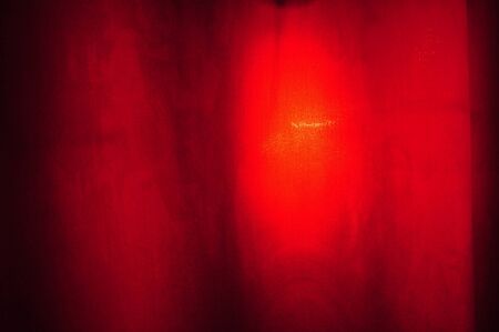 image with a red textile material with light behind good for backgroundの写真素材