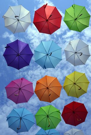 many colorful hanged umbrella against blue skyの写真素材