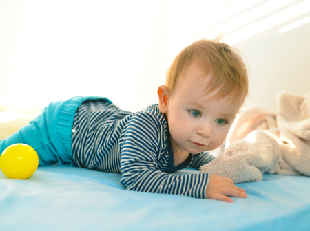 beautiful baby kid playing with a blue ballの写真素材
