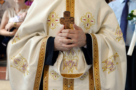 Orthodox priest hands with wooden cross detail