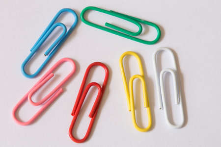 colored paperclips on a white sheetの写真素材