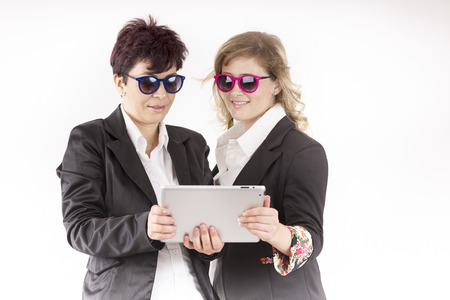 partners with colored sunglasses wotk with the tabletの写真素材