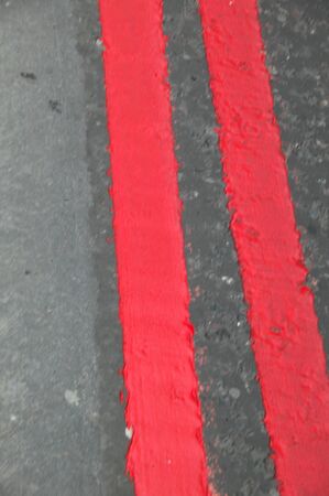 Red lines are painted on the UK streets as a warning that you may not park  your vehicle at any time.の写真素材