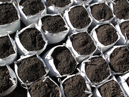 Bags of topsoil stacked in rows ready for landscaping