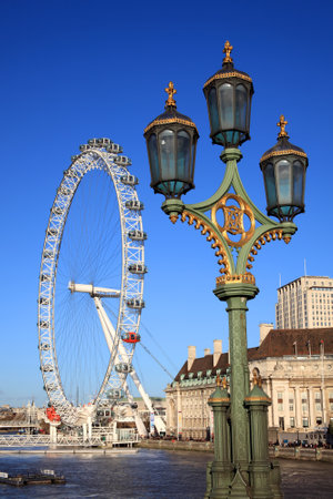 London, UK  November 27, 2011: The London Millennium Eye as seen from Westminster Bridge on the River Thames with one of the bridges lamps in the foregroundのeditorial素材
