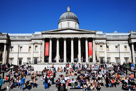 London, UK  April 9, 2011: Tourists and visitors relaxing on a sunny day, on the steps leading up to the entrance of the National Gallery in Trafalgar Square.のeditorial素材