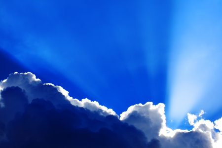 Background of dramatic moody cumulus clouds with sunbeamsの写真素材