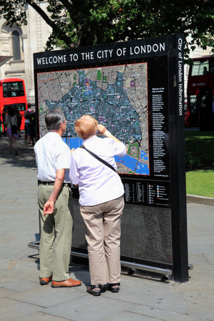 London, UK ? July 26, 2014 : Elderly couple reading a tourist welcome to London information sign mapのeditorial素材