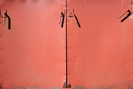 Old cast iron rusty orange distressed sheet metal cabinet doors background surfaceの写真素材