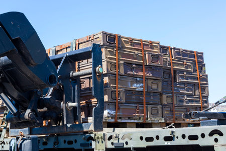 Brown army metal ammunition boxes stacked on a vehicle