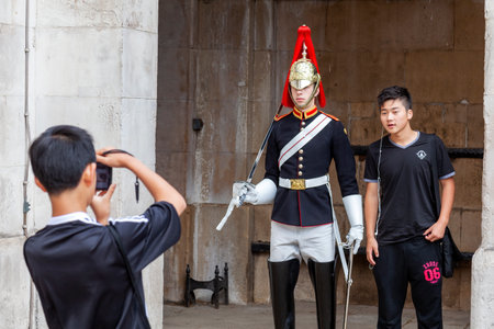 London, UK, July 1, 2012 : Household cavalry soldier on guard at Horse Guards Parade in Whitehall being photographed by tourists which is a popular travel destination tourist attraction landmarkのeditorial素材