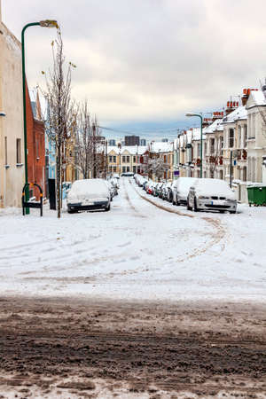 Street winter cityscape with snow terraced houses and frozen cars after a blizzard snowfall in London England UK, stock photo image with copy spaceの写真素材