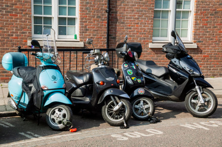 London, UK, March 21, 2009 : Vespa moped and scooters along with a motorbike parked in a solo...